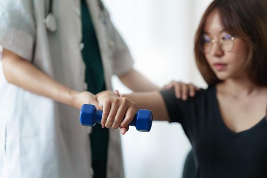 Woman doing the Rehabilitation therapy pain in clinic. Doctor or Physiotherapist. Doctor or Physiotherapist examining treating injured arm and shoulder