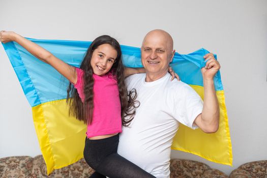 elderly man and girl with the flag of Ukraine.