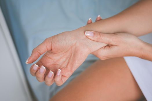 Woman massaging wrist or hand with carpal tunnel syndrome and numbness. High quality photo