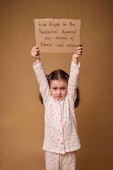 Conceptual studio shot for International Children's Day. Child with advertising banner calling for protection of the rights of children, to protect kids against violence and abuse