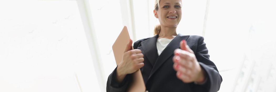 Young woman in business suit stretching out her hand for handshake bottom view. Successful business deal concept