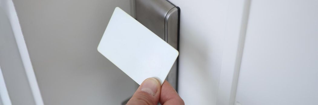 Male hand putting key card to lock on door closeup. Modern door locks concept