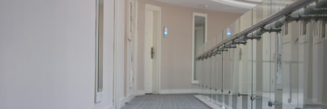 Empty corridor with doors to rooms in hotel building. Modern architecture public building concept