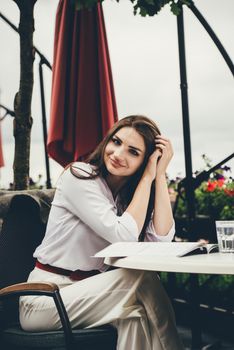 Smiling young dark-haired woman in a cafe. learning