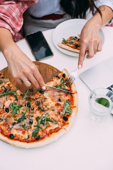 Top view of business woman working on a table at a pizza restaurant