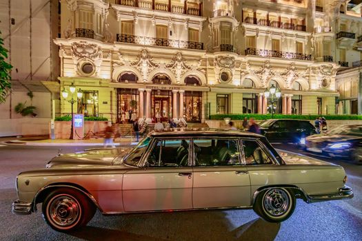 Monaco, Monte Carlo, 21 August 2019: Vintage Mercedes Benz car near the hotel Paris with night illumination, lights of the place Casino. High quality photo