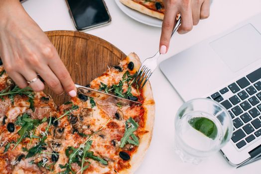 Top view of business woman working on a table at a pizza restaurant