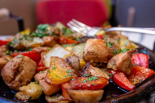 Pan-fried potatoes, meat and vegetables for a large company.