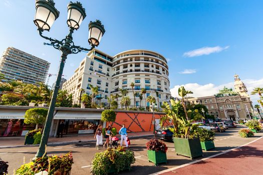 Monaco, Monte-Carlo, 21 August 2017: Tourists and wealthy people visit branded shops near the hotel Paris and Casino Monte-Carlo at sunset, luxury life, expensive cars, wide angle. High quality 4k footage