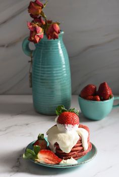 still life with pink strawberry pancakes on a turquoise plate with sour cream and fresh strawberries, cultural exotic food, creative breakfast for Valentine's holiday against a turquoise vase