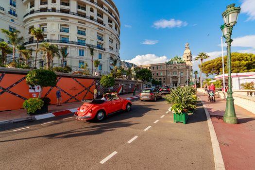 Monaco, Monte-Carlo, 21 August 2017: Tourists and wealthy people visit branded shops near the hotel Paris and Casino Monte-Carlo at sunset, vintage cars, luxury life, expensive cars, wide angle. High quality photo