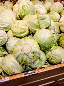 Fresh fruits of white cabbage are in a box in the store
