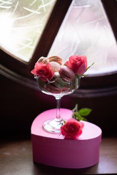 gift box in the shape of a heart with flowers and sweets, pink roses, multi-colored macaroons, still life on the windowsill, congratulations on valentine's day or birthday, high quality photo