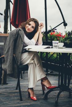 Young brunette woman using laptop computer sitting at cafe table and drik coffe. . Business People Concept