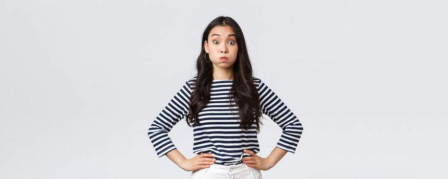 Lifestyle, people emotions and casual concept. Confused cute and puzzled girl pouting, searching for solution, holding breath and staring questioned camera, white background.