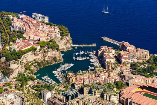 Aerial view of port Fontvieille at sunset, Oceanographic Museum of Monaco, South France, a lot of boats are moored in marina, view of city life from La Turbie mountain, mega yachts, luxury apartments. High quality photo