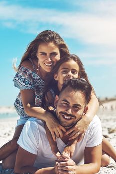 Cropped portrait of a happy young family enjoying their day at the beach.