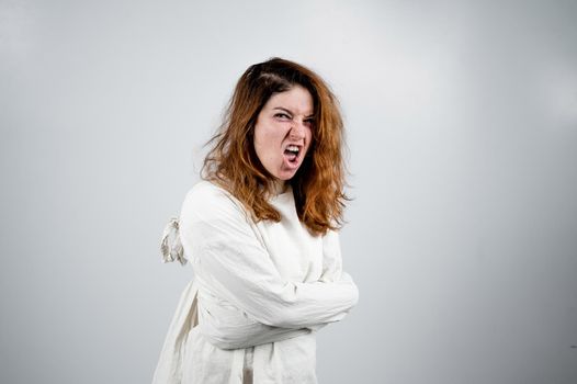 Close-up portrait of insane woman in straitjacket on white background. Monochrome