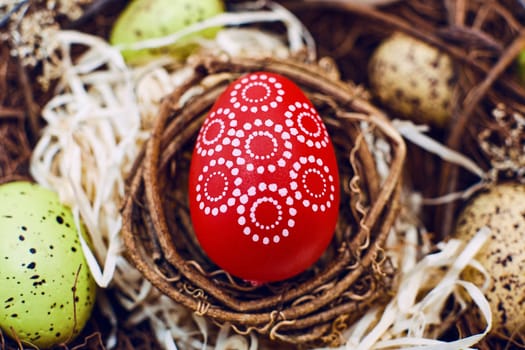 Easter background with colorful eggs in nest. Top view with copy space