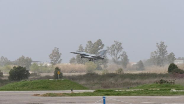 Andravida Greece APRIL, 1, 2022 NATO grey warplane take-off in bad weather condition. Lockheed Martin F-16 Fighting Falcon of Greece Armed Forces