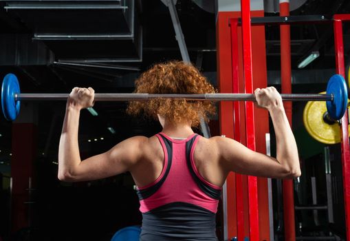 Woman bodybuilder engaged with a barbell in the gym. Healthy lifestyle.