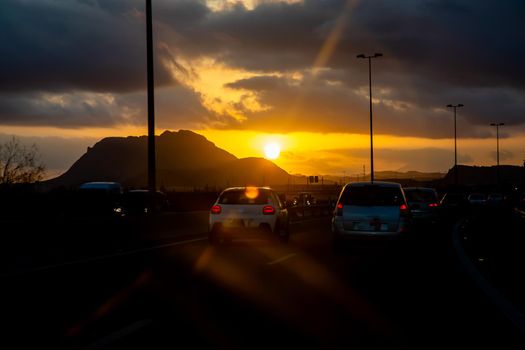 Evening, the sun sets behind the mountain, the view from the car window on the road