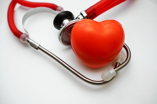 Stethoscope and red heart on white background, heart health, health insurance concept.