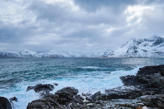 Waves of Norwegian sea crushing at rocky coast in fjord. Vikten, Lofoten islands, Norway