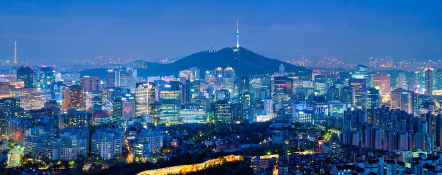 Panorama of Seoul downtown cityscape illuminated with lights and Namsan Seoul Tower in the evening view from Inwang mountain. Seoul, South Korea.