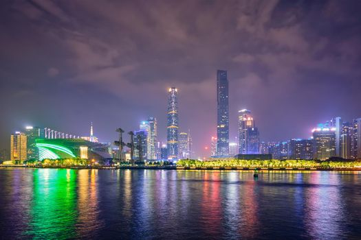 Guangzhou cityscape skyline over the Pearl River illuminated in the evening. Guangzhou, China