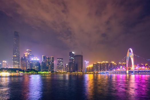 Guangzhou cityscape skyline over the Pearl River illuminated in the evening. Guangzhou, China