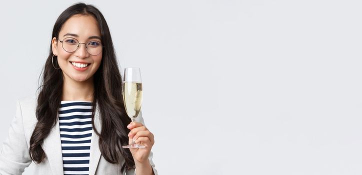 Business, finance and employment, female successful entrepreneurs concept. Happy asian businesswoman celebrating signing of contract, having office party, drinking champagne.