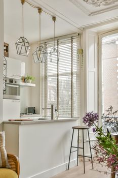 The interior of the kitchen in white tones on the parquet floor in a modern house