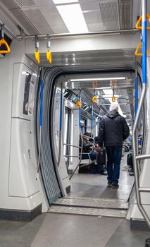 Public transport in the city. Moscow Metro. Yellow handrails for hands close-up. A full subway car lately in the evenings. There are a lot of people in a modern subway car.