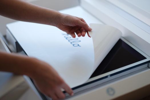 Tbilisi, Georgia - April 11, 2022: Woman removing protective film from New iMac monitor. iMac series of personal quality computers concept