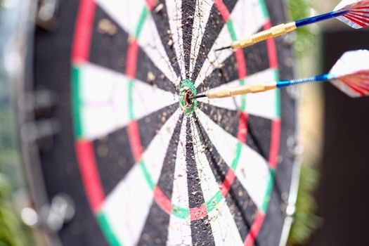 Game darts with dart in center. Achieving goal concept