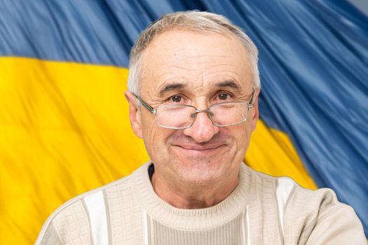 Happy young man on the background of the flag of Ukraine