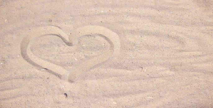 Heart drawn in the sand. Beach background. Top view. selective focus