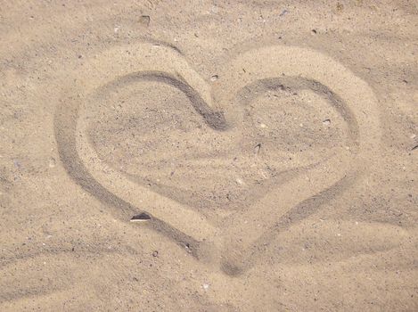 Heart drawn in the sand. Beach background. Top view. selective focus