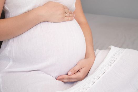 expecting mother with huge tummy. sweet pregnancy time. happy woman with pregnant belly in light bedroom. home cozy interior