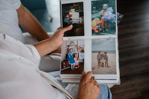 children's photo album with color and black-and-white photos is viewed by adults