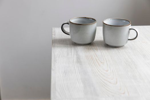 Two porcelain light blue cups are on the table