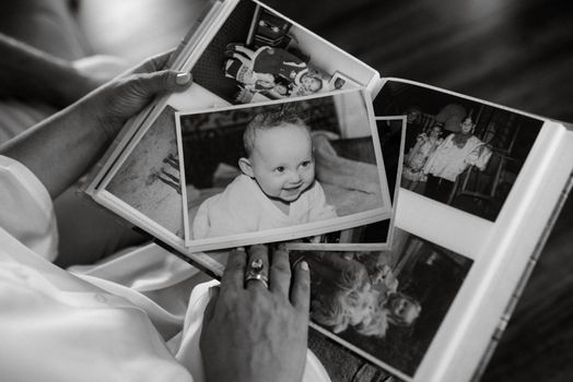 children's photo album with color and black-and-white photos is viewed by adults