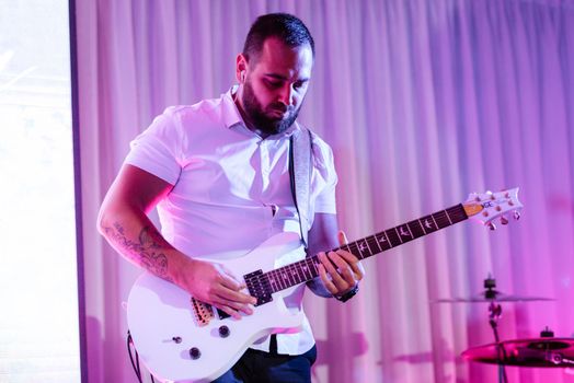 guy musician plays the drum at a concert in stage lighting