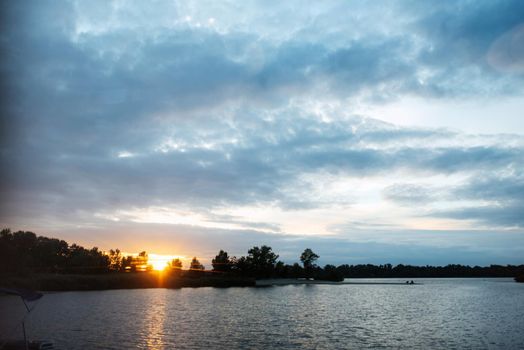 orange sunset on the river with tree silhouettes