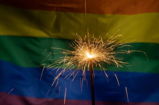 Sparklers with waving lgbt rainbow flag background