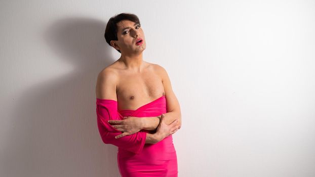 Homosexual in a pink female dress. A man in make-up