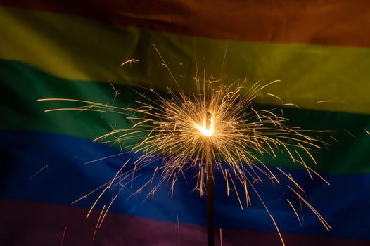 Sparklers with waving lgbt rainbow flag background