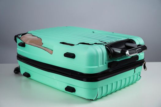 Broken plastic mint suitcase on a white background