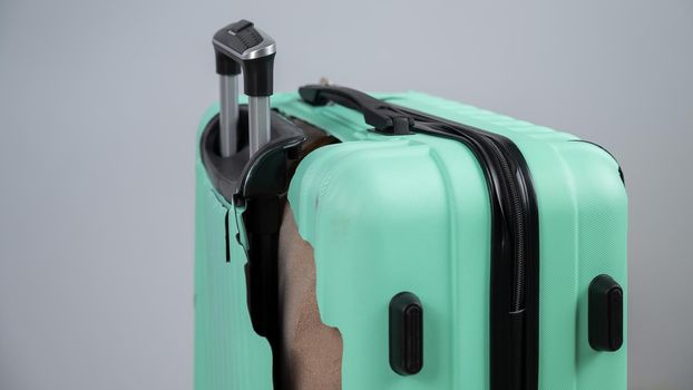 Close-up of a broken plastic suitcase on a white background